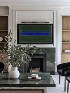 a living room filled with furniture and a flat screen tv mounted on the wall above a fireplace