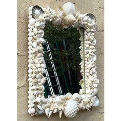 there is a mirror made out of shells on the wall