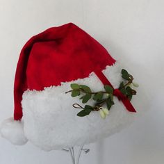 "Get kisses galore this holiday season with a mistletoe Santa hat. This festive Santa hat is made up in a cozy red flannel tie dye cotton fabric. Great novelty party hat. Hat is styled as the traditional cone stocking cap for Santa. Red tie dye flannel is accented with a white faux Sherpa fur fabric trim and a sprig of artificial mistletoe tied with a red velvet ribbon accent is stitched on the fur. Proportions of the hat are generous and will fit most head sizes, ladies or gents. Hat is a soft Oversized Santa Hat, Adjustable Christmas Hat As Gift, Red Christmas Hat For Festive Occasions, Adjustable Red Christmas Hat, Red Adjustable Christmas Hat, Red Christmas Cap, Red Adjustable Mini Hat For Christmas, Adjustable Red Mini Hat For Christmas, Adjustable Red Mini Christmas Hats