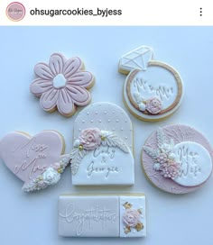 some cookies that are on top of a white table with pink flowers and other decorations