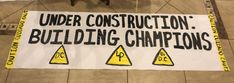 a construction sign is on the floor in front of a chair that says under construction building championships