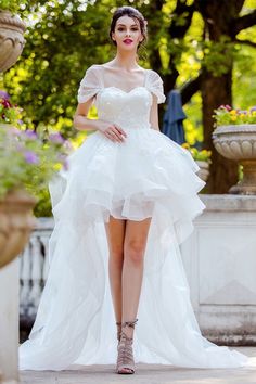 a woman in a white dress is posing for the camera