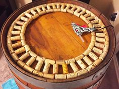 a wine barrel table made out of wine corks with a zebra print umbrella on top