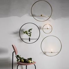 three circular metal wall hangings with flowers in the center and candles on each side