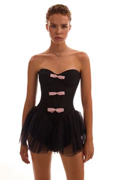 Cute and playful tutu black mini dress with pink bows. Featuring a strapless fitted drop-waist bodice with built-in cups and a hidden zip closure for structure and support. The soft pink bow appliqués and a puffy tulle skirt bring a quirky, almost theatrical vibe to the look.Details: Material: Khayal Fabric composition: 92% Polyester; 8% Elastan Sleeve style: Sleeveless Silhouette: Fitted Skirt length from waist: 5.9 inches / 15 cm Neckline: Sweetheart Back: Zip closure Lining: Mini-length skirt Black And Pink Halloween, Asymmetrical Dress Casual, Puffy Tulle Skirt, Princess Silhouette, Wedding Guest Style, Pink Bows, Winter Formal, Pink Halloween, Black Mini Dress