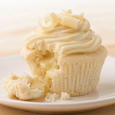 a white plate topped with a cupcake covered in frosting