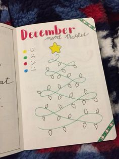 an open book with writing on it and a christmas tree drawn on the page next to it