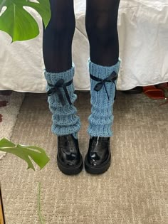 the legs of a woman wearing black boots and socks with blue knitted garters