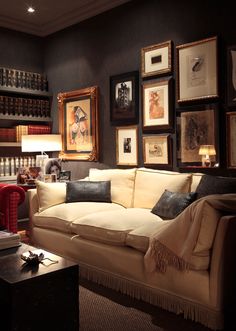 a living room filled with furniture and framed pictures on the wall above it's couch