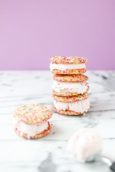 several cookies with sprinkles and icing stacked on top of each other