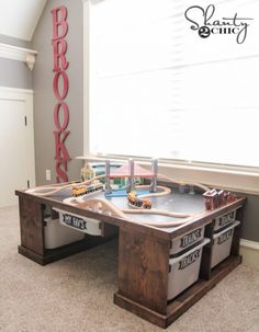 a toy train table in the corner of a room