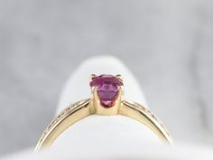 Finely crafted, this yellow gold mounting came to us without stones. Rather than a traditional diamond, we chose to set this lovely piece with one of our finest Ceylon Sapphires. This stone is rich with color, a soft pink reminiscent of springtime cherry blossoms! Metal: 14K Yellow Gold Gem: Pink Sapphire totaling .79 Carats Gem Measurements: 4.6 x 5.6 mm, Oval Accents: 8 Diamonds totaling .12 Carats, H in Color, SI in Clarity Ring Size: 6.75 Marks: "LIM 14K" Stamped on the inside band Gold Pink Sapphire Diamond Ring, Round Cut, Gold Diamond Ring With Pink Sapphire In Prong Setting, Pink Ruby Ring With Diamond Accents, Yellow Gold Pink Sapphire Diamond Ring With Accent Stones, Elegant Pink Ruby Ring With Round Band, Luxury Pink Solitaire Ring, Pink Ruby Ring With Brilliant Cut In 14k Gold, Pink Brilliant Cut Ruby Ring In 14k Gold, Elegant Pink Ruby Ring With Diamond Cut