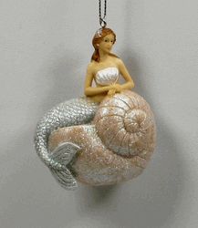 a glass ornament with a woman sitting on top of a large snail shell