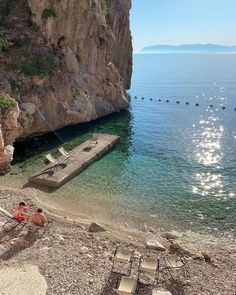 there is a boat that is sitting on the beach next to the water's edge