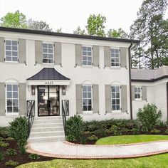 a large white house with many windows and steps leading up to the front door area