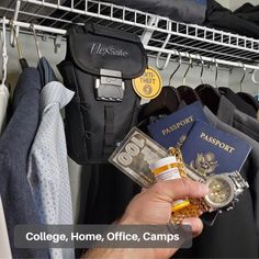 a person holding a passport, money and other items in front of a rack with clothes