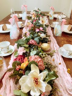 a long table with flowers and candles on it is set up for a formal dinner