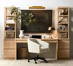 a desk with a chair, lamp and bookshelf in front of a painting