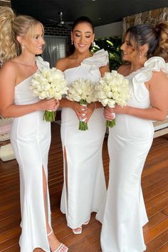 three bridesmaids in white dresses holding bouquets