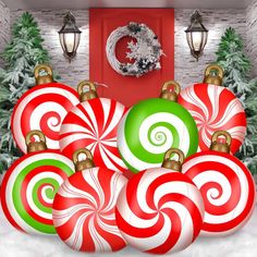 christmas decorations in front of a red door with green and white ornaments on the outside