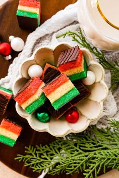 a plate with pieces of cake on it next to a glass of milk and christmas decorations