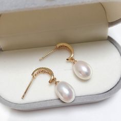 Featuring captivating oval pearls set within a graceful arch of shimmering zircons. The 18K gold plating adds a touch of modernity and makes them long-lasting, non-tarnishing for years! Pearl Type: Freshwater Pearls Pearl Quality: [Shape]: Oval [Size]: 8-9mm [Blemish]: None [Luster]: High Material: Thick 18k Gold Plated Brass Note: Every pearl is unique. Items may vary from the pictures. Luxury Oval Pearl Drop Jewelry, Wedding Oval Pearl Earrings, Oval Pearl Earrings For Gifts, Elegant Oval Pendant Earrings For Anniversary, Elegant Oval Jewelry With Pearl Charm, Oval Pearl Charm Earrings For Wedding, Elegant Oval Gold Plated Earrings, Wedding Yellow Gold Oval Pearl Earrings, Luxury Oval Pearl Drop Earrings