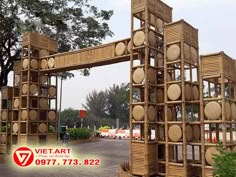 a wooden structure made out of barrels and baskets on the side of a road with trees in the background