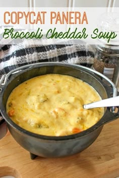 a pot filled with broccoli cheddar soup on top of a wooden cutting board