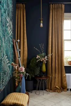 a living room with blue walls and curtains on the windowsills, a bench in front of a window