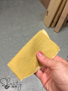 a hand holding a piece of yellow paper