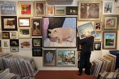 a man standing in front of a wall full of pictures