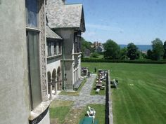 an aerial view of a large house with lawn chairs in the foreground and ocean in the background