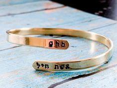 Celebrate your strength with this personalized wraparound bangle bracelet. Fashioned in brass, sterling silver, 14K gold filled, or 14K rose gold filled, this meaningful design showcases a trendy, sleek wraparound design. Complete this look with two names or phrases of your choice - each up to seven characters in length - inscribed in a tiny English and Hebrew font. FEATURES Adjustable - just slip on like a bangle bracelet and give a gentle squeeze 4.5-5mm wide Choose your wrist size and I will Customizable Adjustable Jewelry, Adjustable Bangle Cuff Bracelet For Anniversary, Adjustable Name Bracelet For Anniversary, Adjustable Stackable Cuff Bracelet For Anniversary, Adjustable Engraved Jewelry For Anniversary Gift, Spiritual Wrap Bangle Bracelet As Gift, Mother's Day Bracelet Jewelry For Anniversary Gift, Personalized Adjustable Bracelet For Anniversary Gift, Mother's Day Personalized Stackable Jewelry