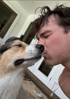 a man kissing his dog on the nose