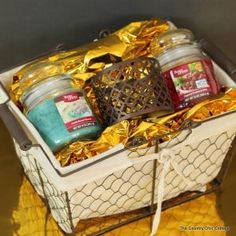 a basket filled with candles and wrapped in gold foil