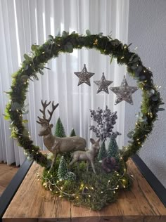 a christmas wreath with deer, pine cones and evergreens in the shape of stars