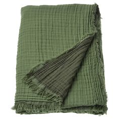 a green blanket with fringes on it