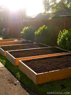 several raised garden beds with dirt in them