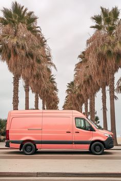 an orange van parked in front of palm trees