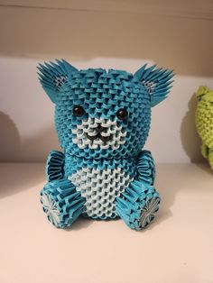 a blue and white teddy bear made out of small pieces of origami paper