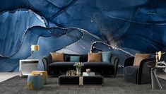 a living room filled with black couches and blue art work on the wall behind them