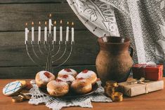 a hanukkah menorah with donuts and gifts on a table