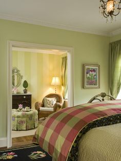 a bedroom with green walls and plaid bedspread on the bed is decorated in an antique style