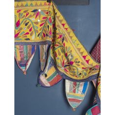 three pieces of cloth hanging on the wall next to each other with different designs and colors