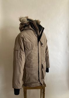 1980er Kanadagans Khaki Gänse down gefüllter Parka mit Kojoten pelz Zierhaube Reißverschlüsse vorne und hat einen Klettverschluss, um die Kälte fernzuhalten. Vorne gibt es vier aufgesetzte Taschen mit Klettverschluss; die beiden Hüfttaschen haben seitliche Reißverschlusstaschen und sind mit schwarzem Flanell gefüttert. Es gibt eine weitere Tasche auf der Innenseite und einen Klettband, um jede kalte Brise unter dem Saum des Mantels zu halten. Gans Daunen gefüllte Kapuze hat Draht in ihr, um ihre Khaki Parka, Black Flannel, Coyote Fur, Guys Be Like, Canada Goose, Parka, Zip Pockets, Zip Ups, Two By Two