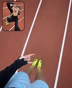 a woman in black shirt and yellow shoes sitting on a track with her hand up to her head