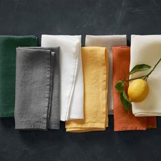 five different colored napkins with a lemon on one side and two green leaves on the other