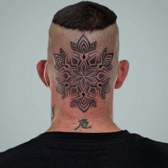 the back of a man's head with a tattoo design on his forehead and neck