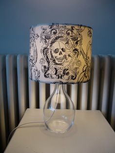 a lamp with a skull on it sitting on a table next to a radiator