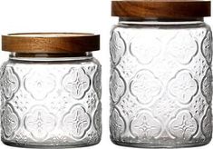 two glass jars with wooden lids are shown